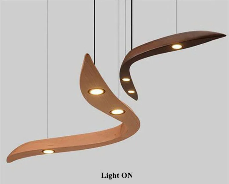 Two Spiral Wood Pendant Lights with integrated LED bulbs hang from the ceiling, both lit against a plain background, showcasing an organic modern design.