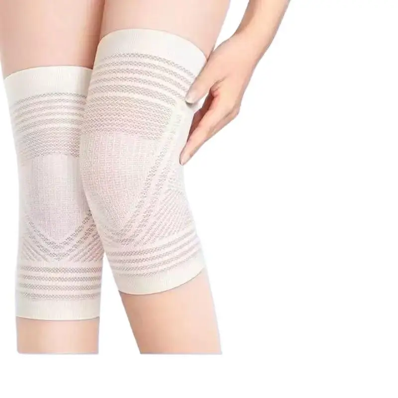 Genouillères de protection sport beige portées sur un genou plié, montrant la flexibilité du tissu.