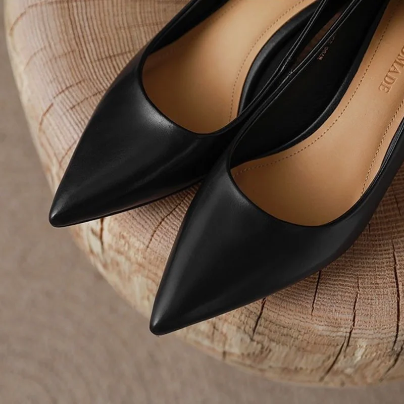 Black Pointed Toe Kitten Heel Pumps Black pointed toe kitten heel pumps displayed on a wooden surface