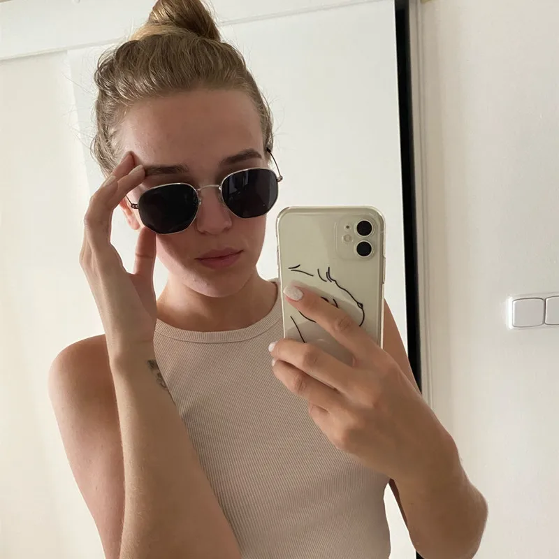 A woman taking a selfie in a mirror wearing Metal Frame Hexagon Sunglasses UV400.