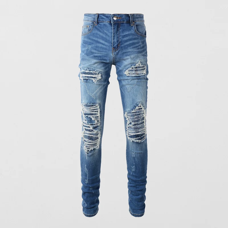 

Fashionable street men's blue jeans. Elastic slim fit retro slit jeans with distressed patches. Designer hip-hop brand pants