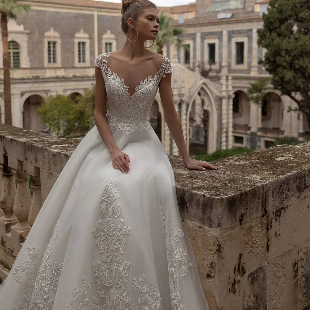 

Elegant Cap Sleeves Wedding Dress High Quality Appliques Illusion Back Organza Floor Length Brush Trail Bridal Robe Gowns