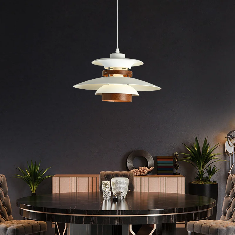 A Scandinavian dining room with a black table and chairs, adorned with a pendant light.