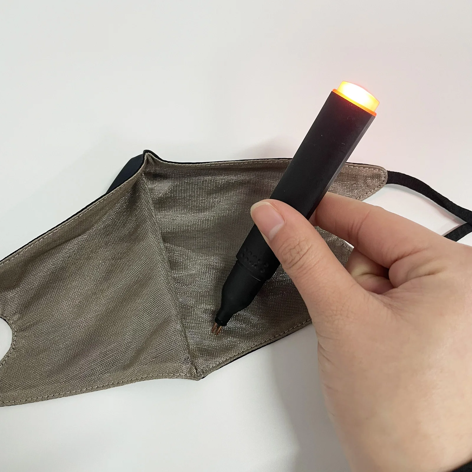 Masque en fibre d'argent antibactérien et anti-radiation - Protection santé réutilisable, plié à côté d'un écran