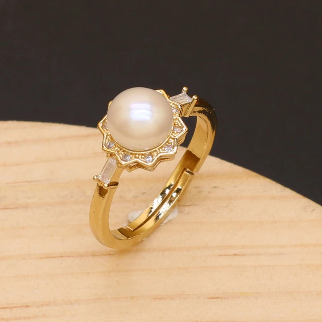 Fashion yellow gold ring decorated with natural white freshwater pearl,  close up Stock Photo - Alamy