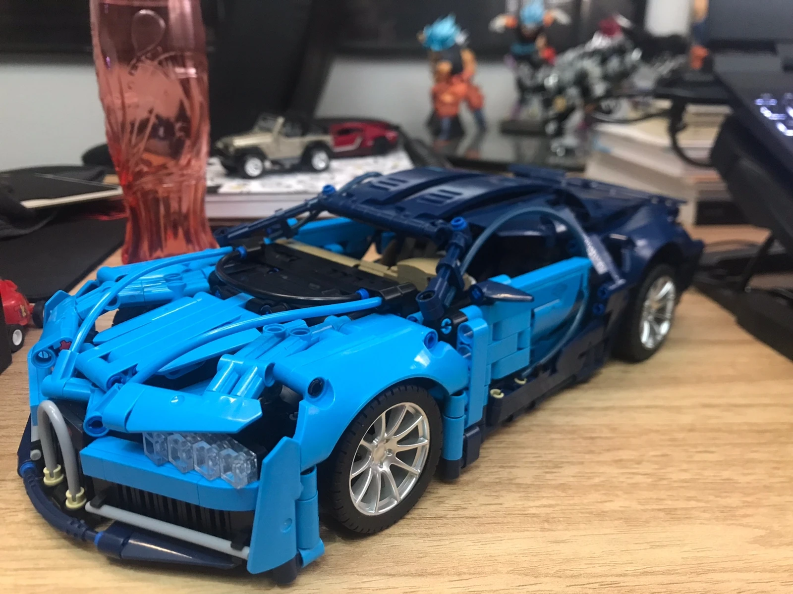 Proceso de montaje del supercoche azul: piezas organizadas y modelo en construcción