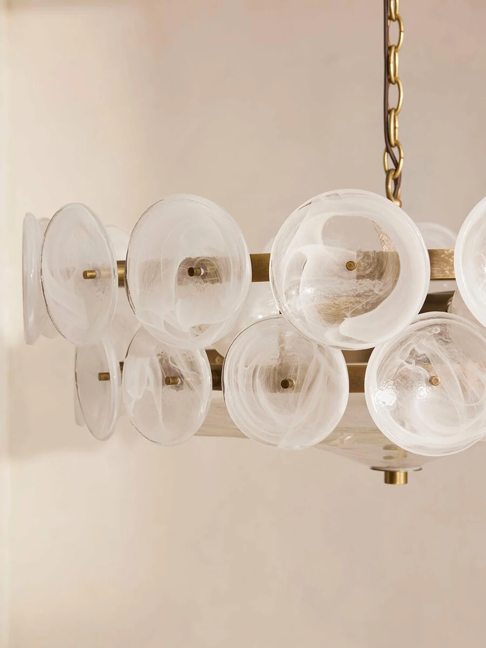A close-up of the Italian Retro Pendant Light, featuring frosted glass disc shades and suspended by a chain against a neutral wall.
