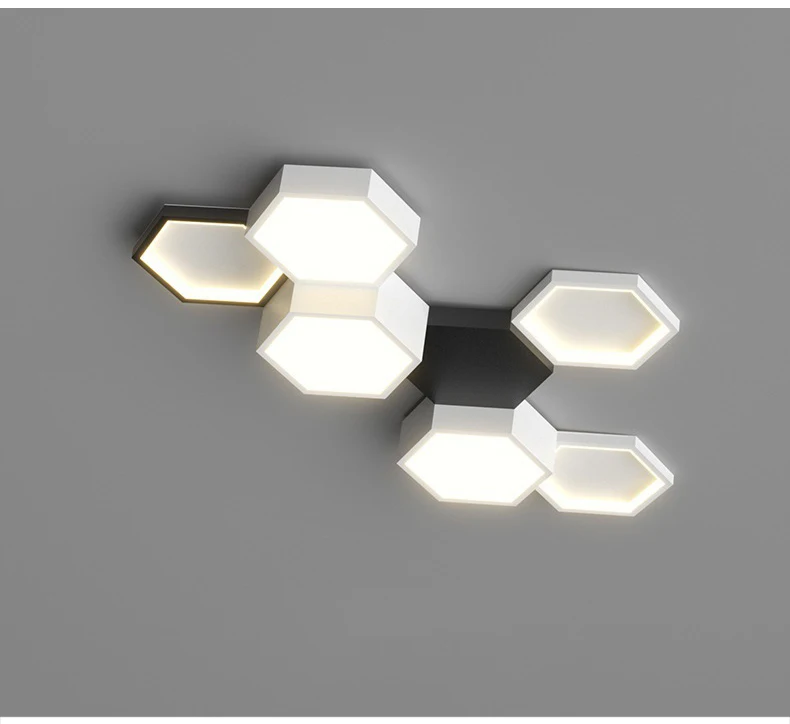 Three hexagonal ceiling lights emitting a soft glow mounted on a gray surface.