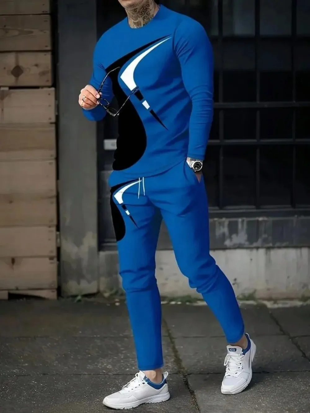Man wearing striped patchwork long sleeve top and pants set in a sunny outdoor setting blue