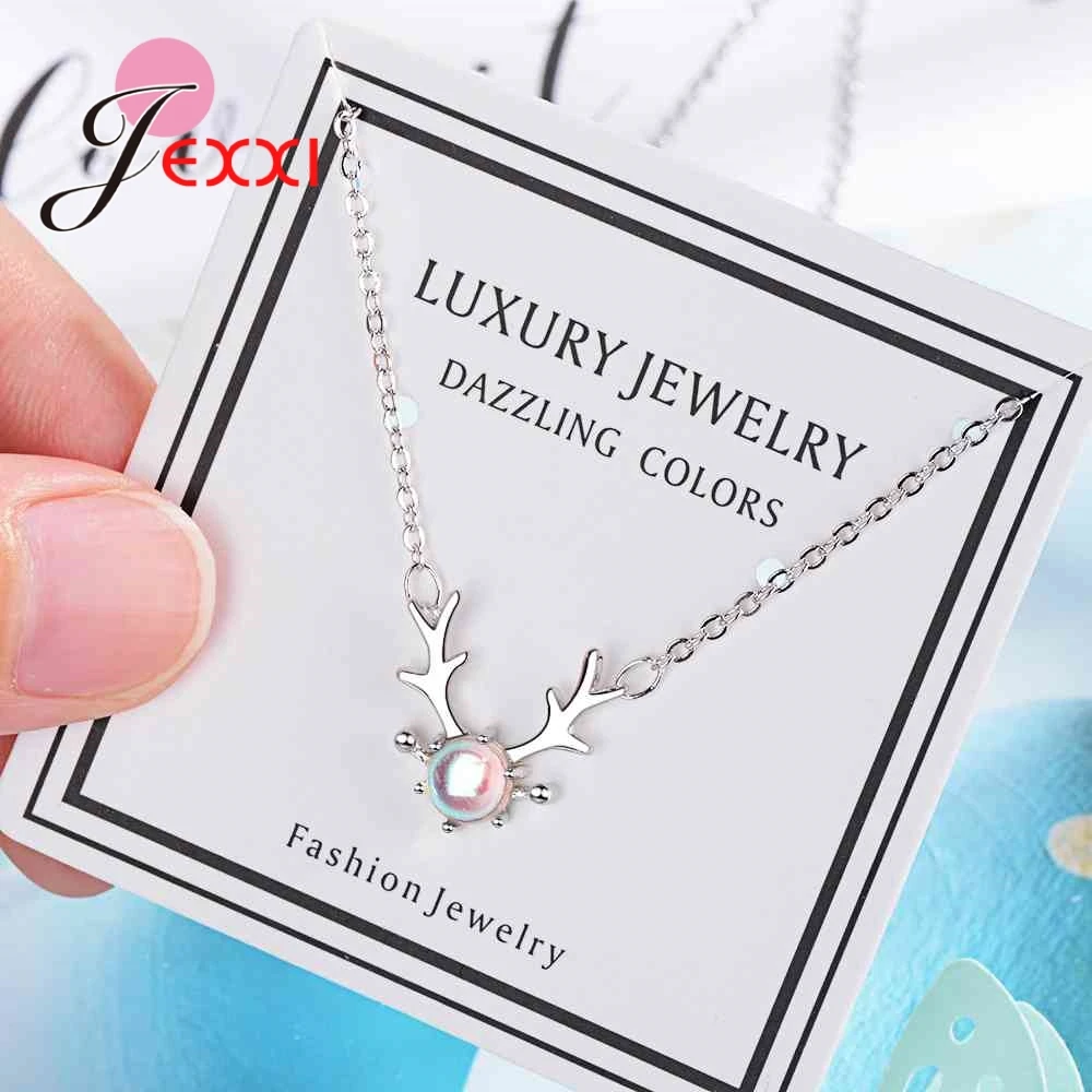 Sterling silver deer antler necklace featuring a central iridescent pearl pendant displayed on a branded luxury jewelry card.