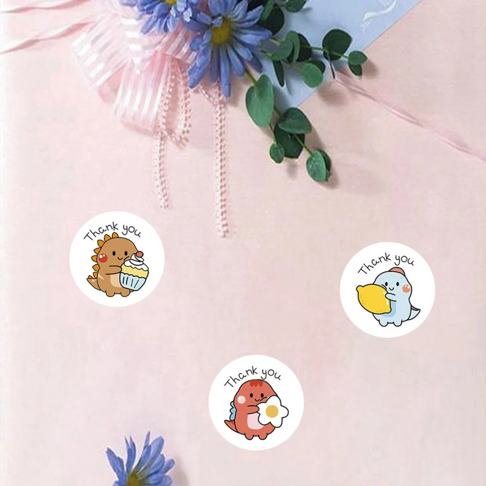 Hand applying thank you dinosaur sticker to packaging