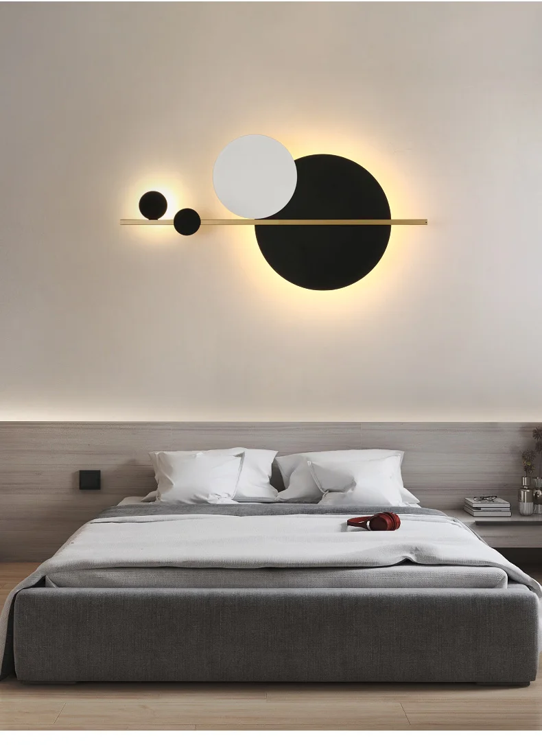 A minimalist bedroom with a bed and a matte black wall sconce.