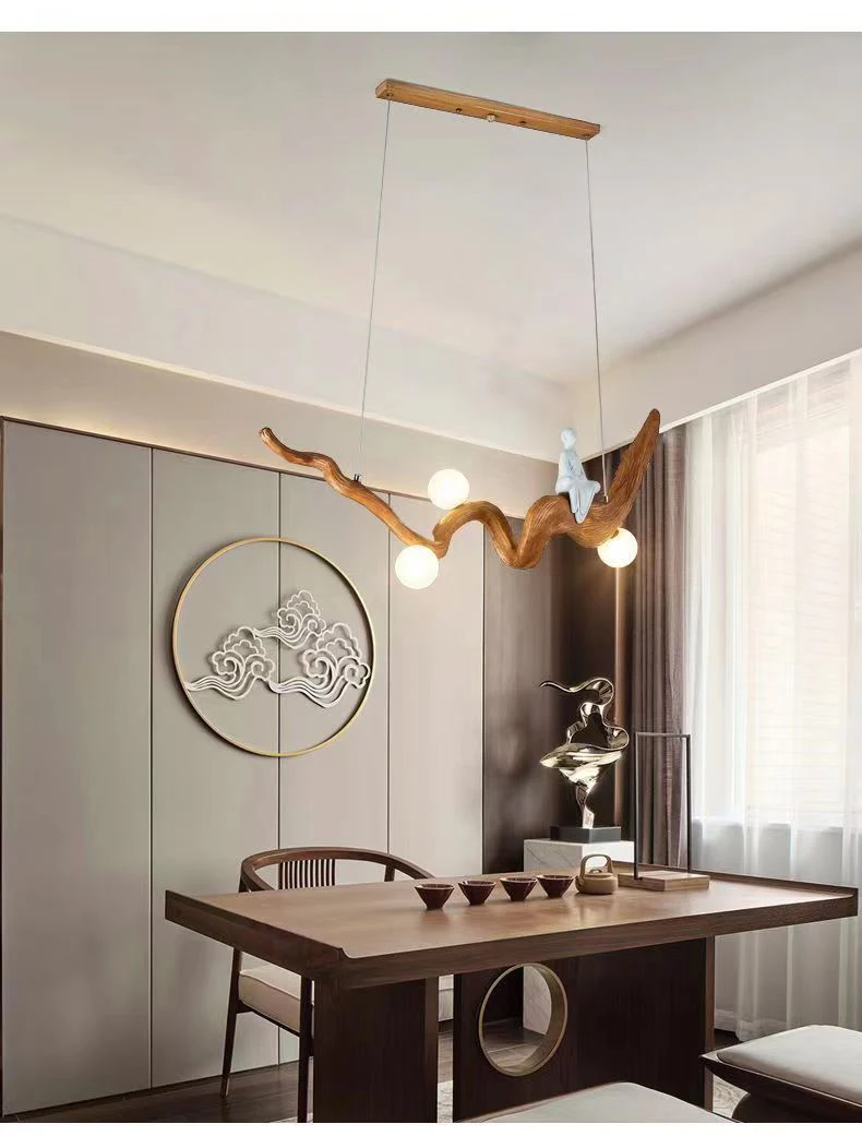 A modern dining room exudes a Zen vibe, showcasing a natural wood table and the Zen-Inspired Wooden Pendant Light. Decorative wall art and a metal sculpture on the table complete the serene and stylish ambiance.