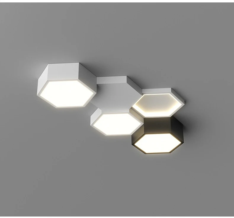 Modern hexagonal wall sconces with adjustable lighting, emitting white light, mounted on a gray surface, arranged in an abstract, branching pattern.