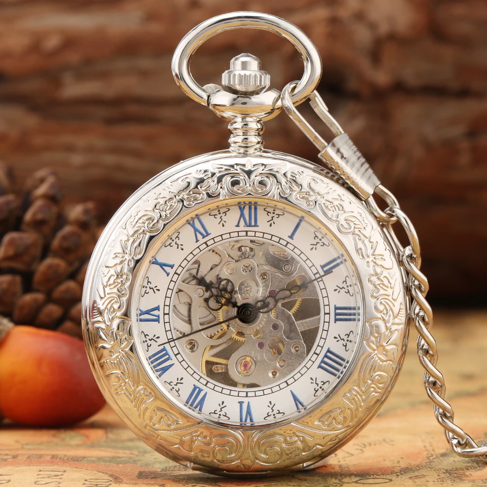The Silvery Pocket Watch, featuring a skeleton dial with visible gears and blue Roman numerals, rests on a textured surface with a pinecone and fruit in the background.