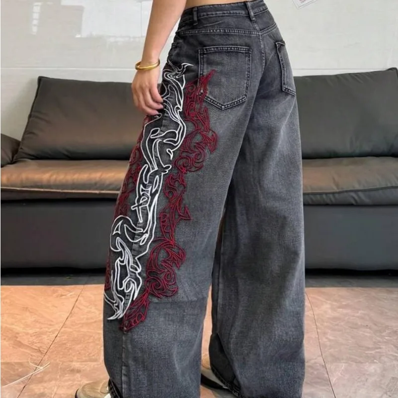 Jean vintage gris foncé délavé pour femme, taille haute, coupe large, avec broderie abstraite rouge et blanche sur le côté, en denim, collection été 2026, style streetwear européen