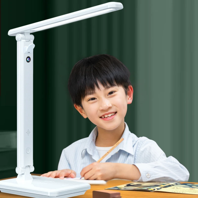 A young boy sitting at a desk with a SpyCam Desk Lamp.