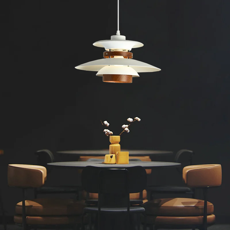 A Scandinavian-inspired dining room with a natural wood table and chairs, featuring a pendant light.