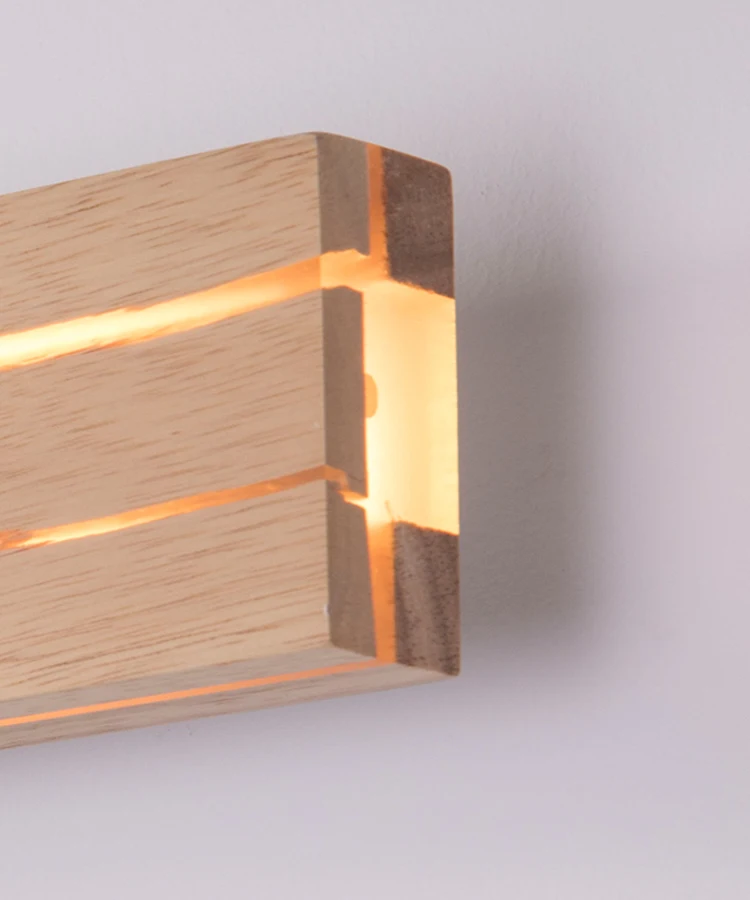 Close-up of the Rectangle Wood Wall Light, a minimalist LED fixture featuring a wooden look and warm illumination through horizontal slits for ambient lighting.