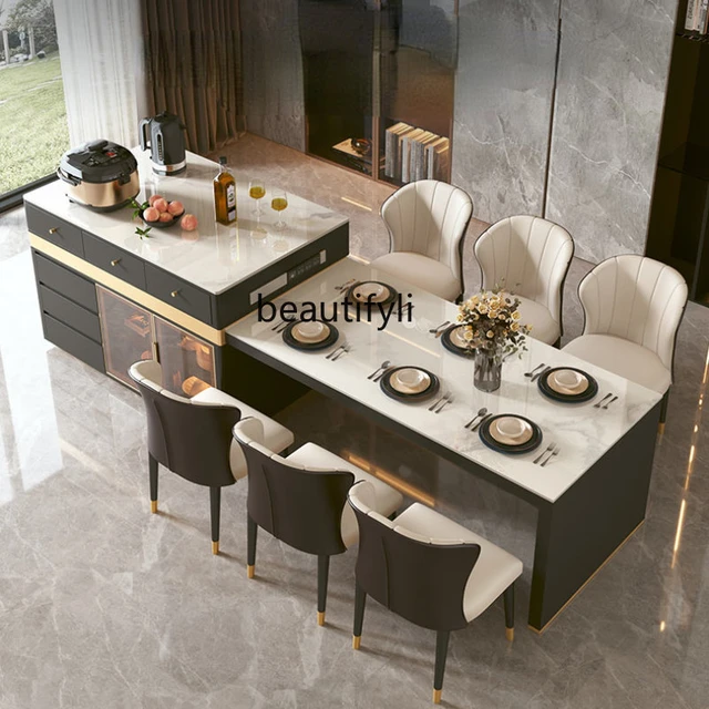 Mesa de comedor de madera moderna, encimera de mármol con isla, dos sillas  altas en un mostrador de cocina beige de lujo con hola