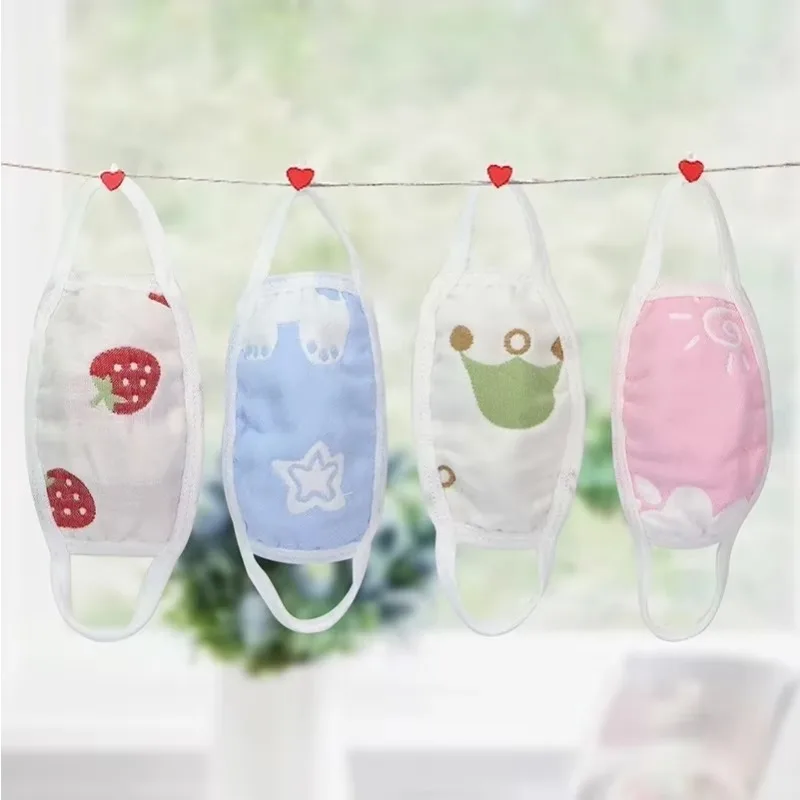 Masque en gaze de coton 6 couches lavable et réutilisable pour enfant et adulte, porté par un enfant souriant