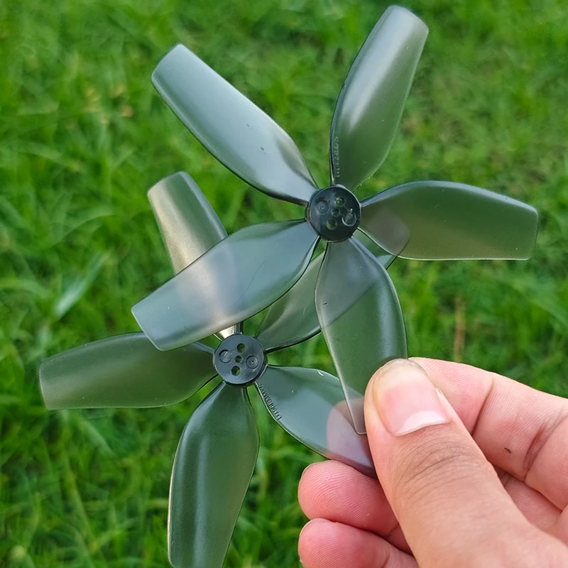 Hélice 5 pales 90mm pour drone RC, posée sur fond blanc, montrant sa transparence et sa légèreté en polycarbonate.