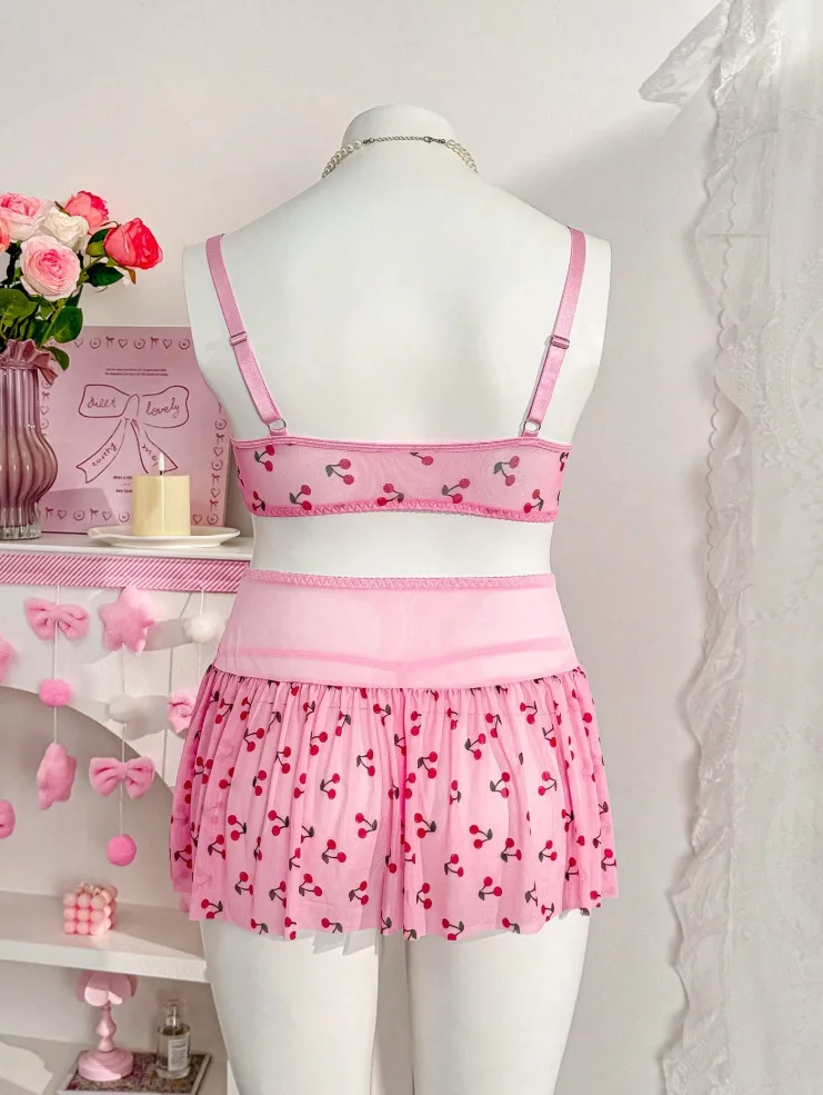 Romantic lingerie styling with soft pink fabric, cherry print, and feminine skirt shape
