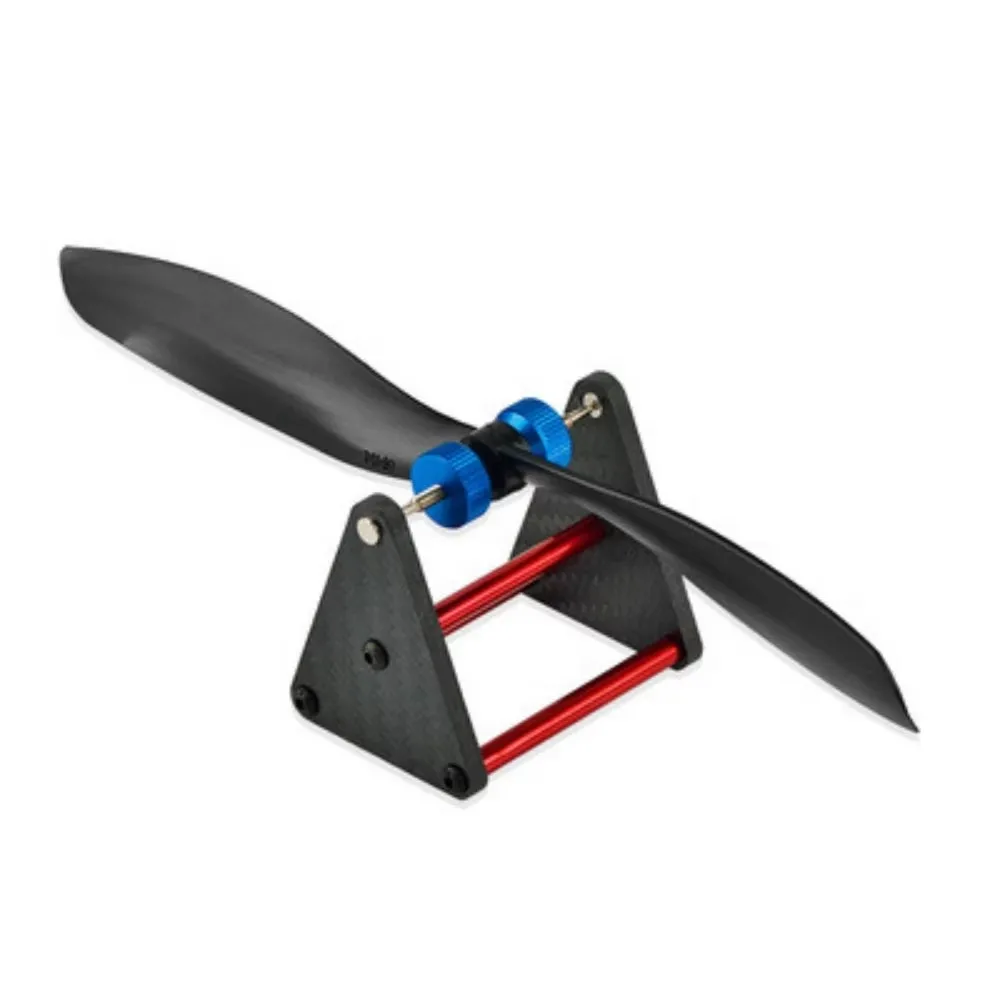 Main tenant l'équilibreur d'hélice magnétique pour quadrirotor, hélicoptère et avion, mettant en valeur sa légèreté et sa finition en fibre de carbone.