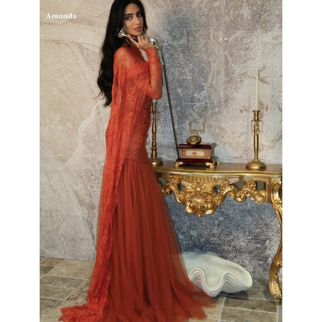 A custom evening dress from Amanda in rust orange with a lace bustier and flowing tulle cape details, formal evening dresses