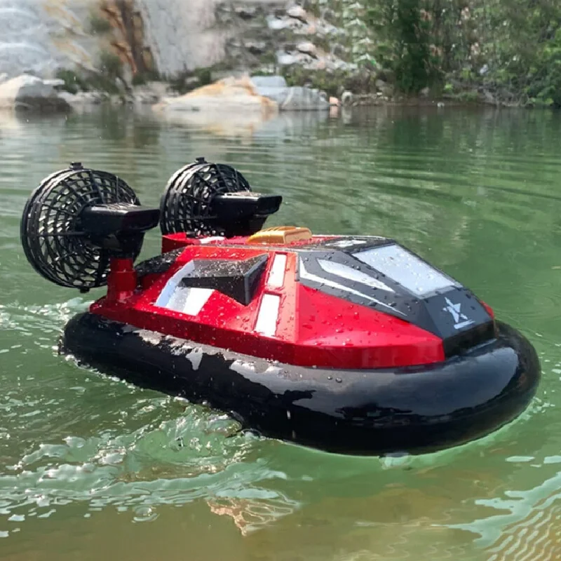 Enfant souriant utilisant la télécommande pour diriger l'hovercraft amphibie sur un lac.