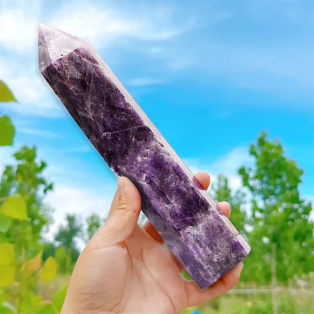 A substantial, naturally formed Amethyst crystal point, showing a deep violet to lavender hue and rough, textured sides leading to a terminated tip.