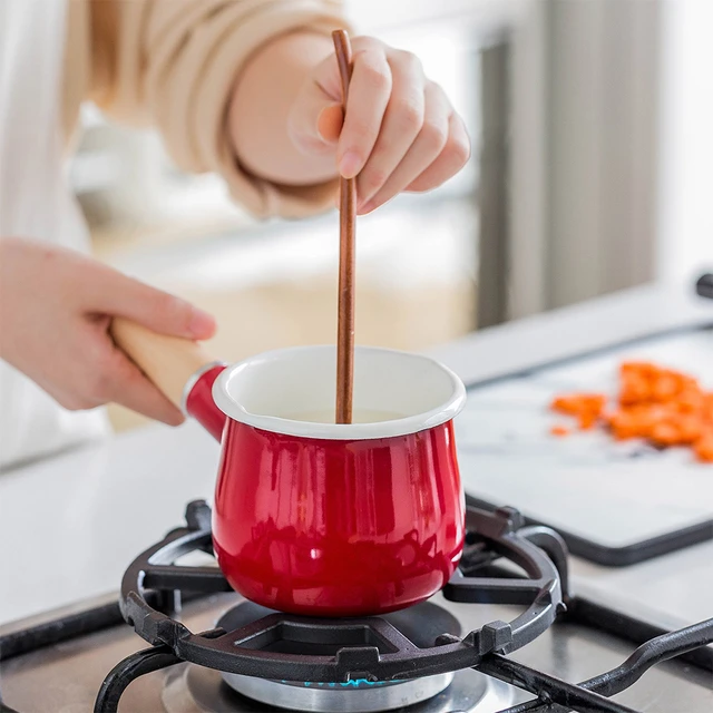 Une Casserole Sur Une Cuisinière à Gaz Avec Une Poignée Rouge