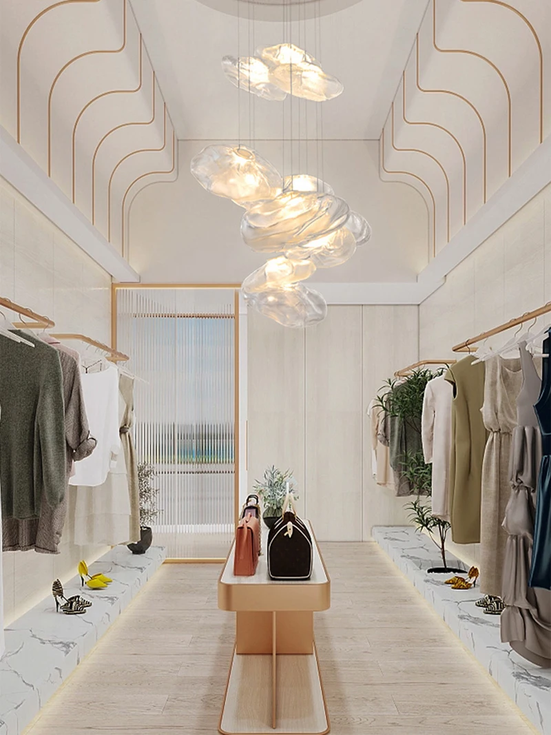 Modern walk-in closet with clothes and accessories on both sides, a central bench with handbags, light wood flooring, and the Luxe Cloud Glass Pendant Light suspended from the ceiling.