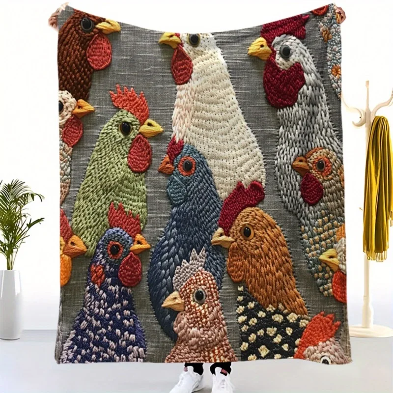 A woman holding a gray fleece blanket featuring a colorful vintage rooster and chicken pattern.