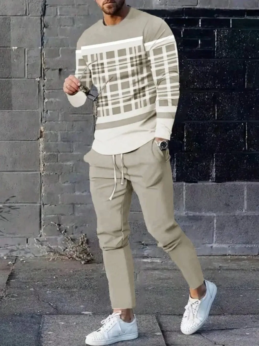 Man wearing striped patchwork long sleeve top and pants set in a sunny outdoor setting beige