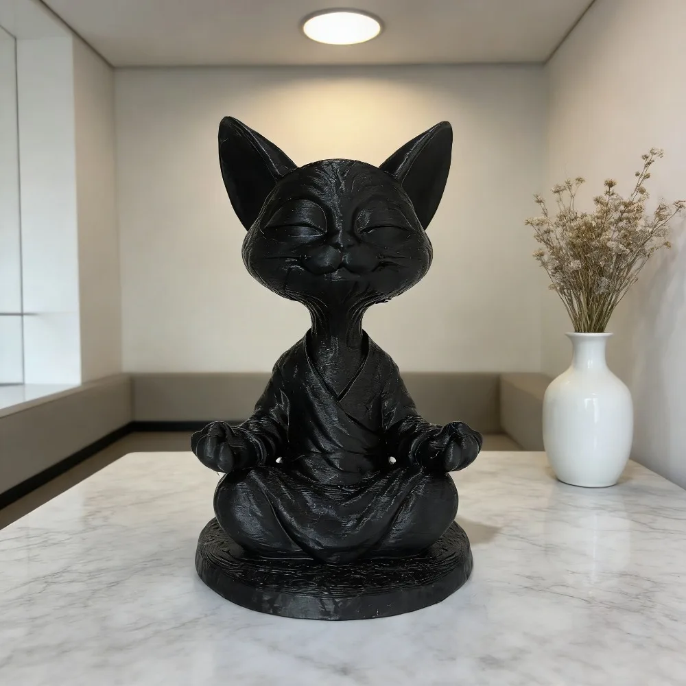 A black textured resin cat statue sitting in a calm yoga meditation lotus pose on a beige tablecloth next to a small white vase.