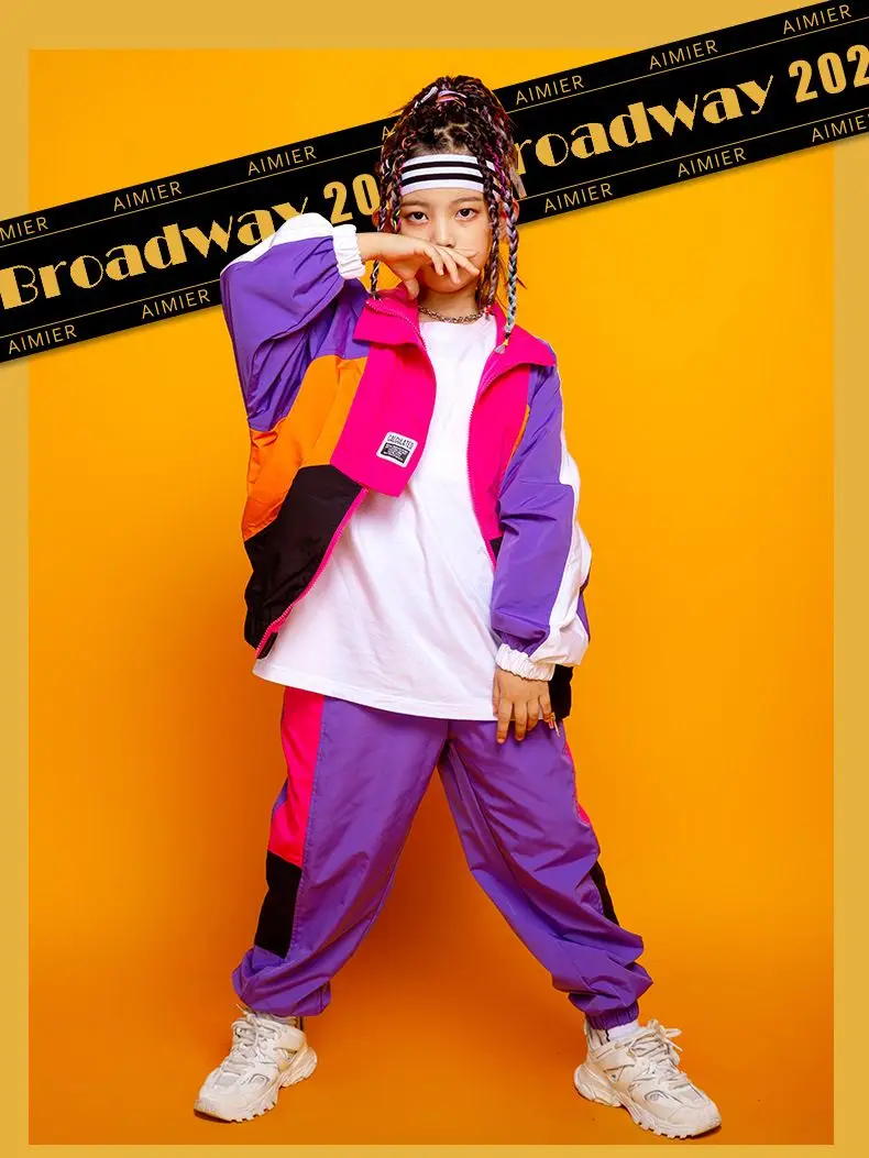 Child wearing patchwork jacket and joggers in hip hop street dance pose