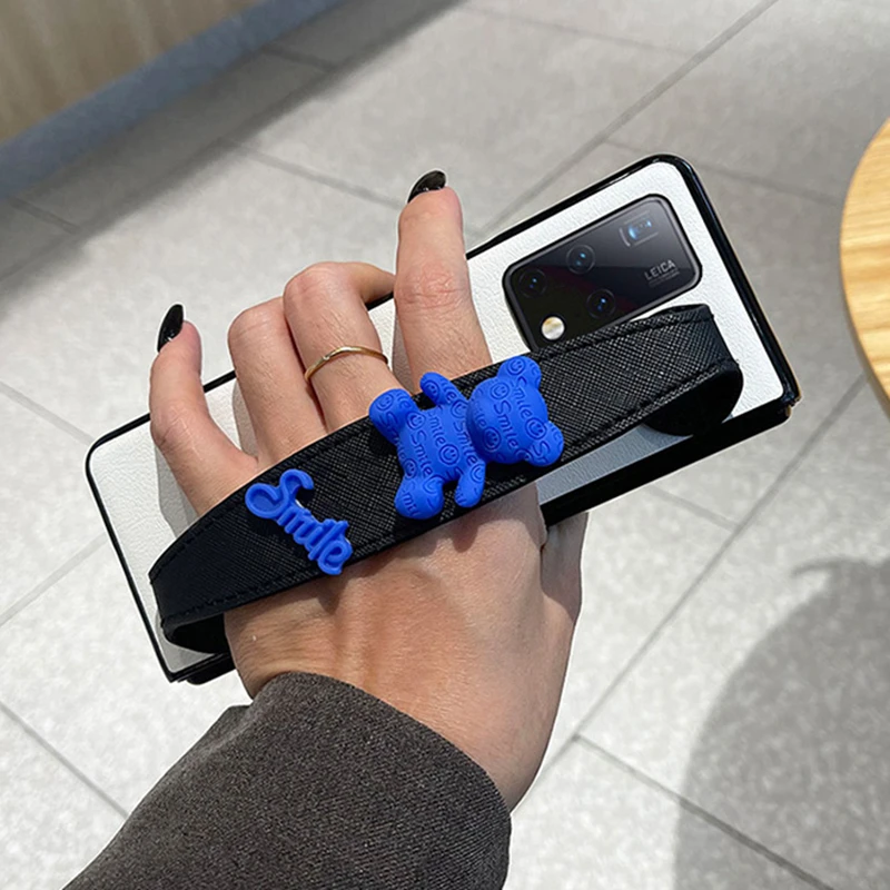 

Fashion Smile Bear Wristband Leather Phone Case For Samsung Galaxy ZFold 5 Z Fold 4 Z Fold 3 ZFold 2 Girl Hand Holder Back Cover
