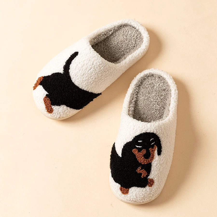 White fuzzy slippers with black and brown dachshund embroidery