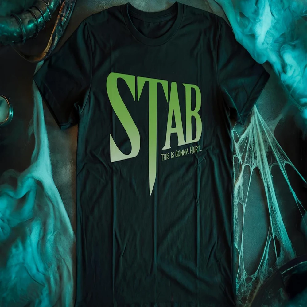 STAB Scream Movie T-Shirt mit gruseligem Gesichtsaufdruck, Rundhalsausschnitt, kurzen Ärmeln und auffälligem fluoreszierendem grünen Aufdruck. Ein stilvoll bedrucktes T-Shirt