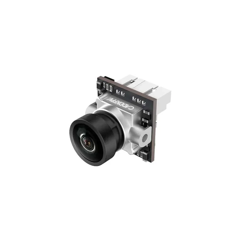 Caméra FPV Caddx Ant 1200TVL posée sur une surface plane, avec câble et connecteur visibles.