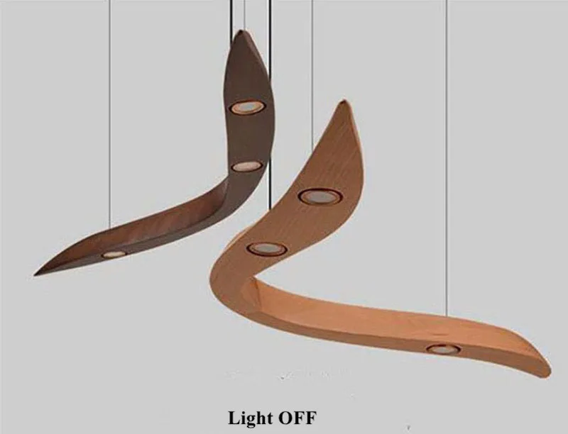 Two Spiral Wood Pendant Lights, featuring a boomerang-shaped wooden design with embedded circular fixtures in the Organic Modern style, hang from the ceiling; the lights are turned off.