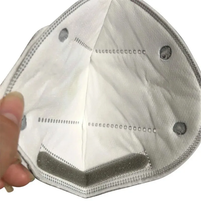 Détail de la valve respiratoire du masque anti-poussière, avec indication du sens d'expiration.