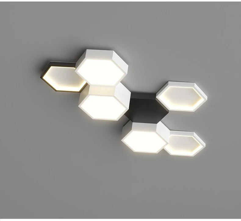 Three hexagonal wall-mounted led lights with adjustable lighting, emitting a soft glow, arranged cluster-style on a gray background.