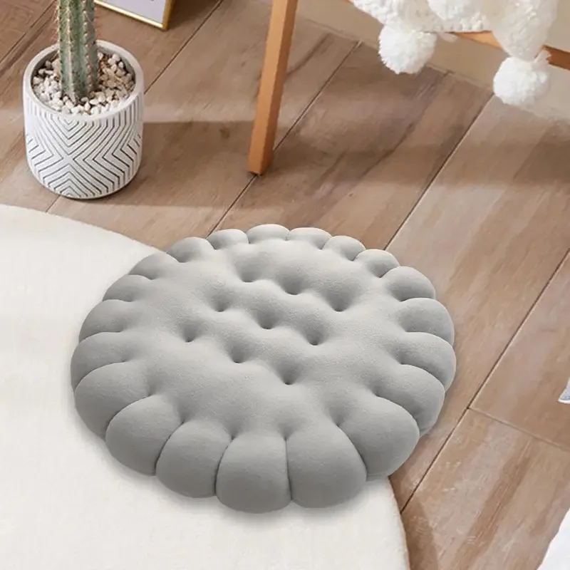 Biscuit kussen grijs op houten vloer naast cactus en pompon stoel