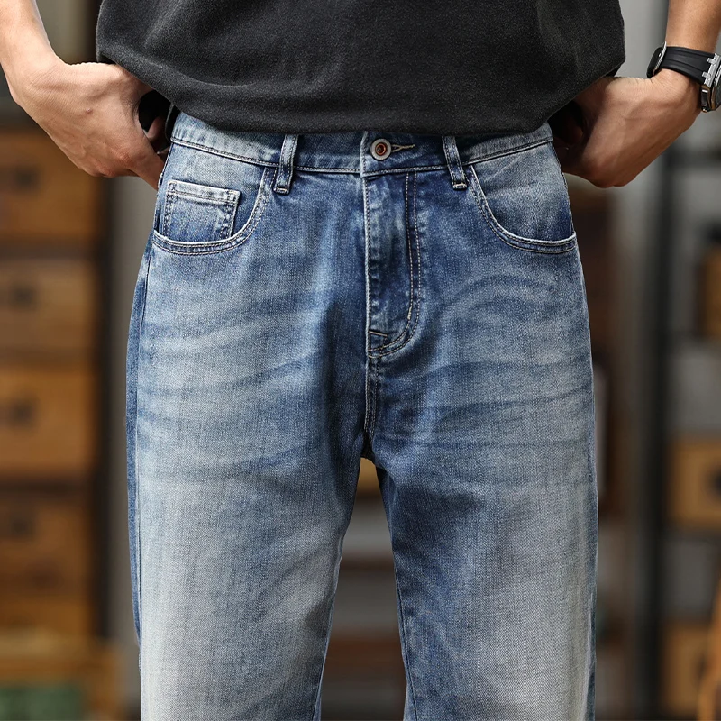 Jeans amples en denim bleu clair en denim bleu, avec un aspect usé et délavé, ainsi qu’une conception classique à cinq poches.