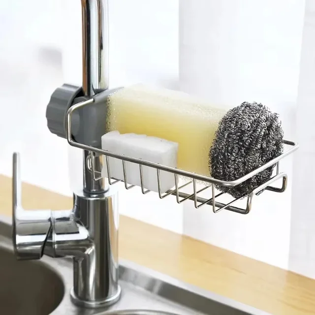 A sleek, stainless steel faucet sponge holder clamped onto a modern kitchen faucet, holding a sponge and a dish brush.