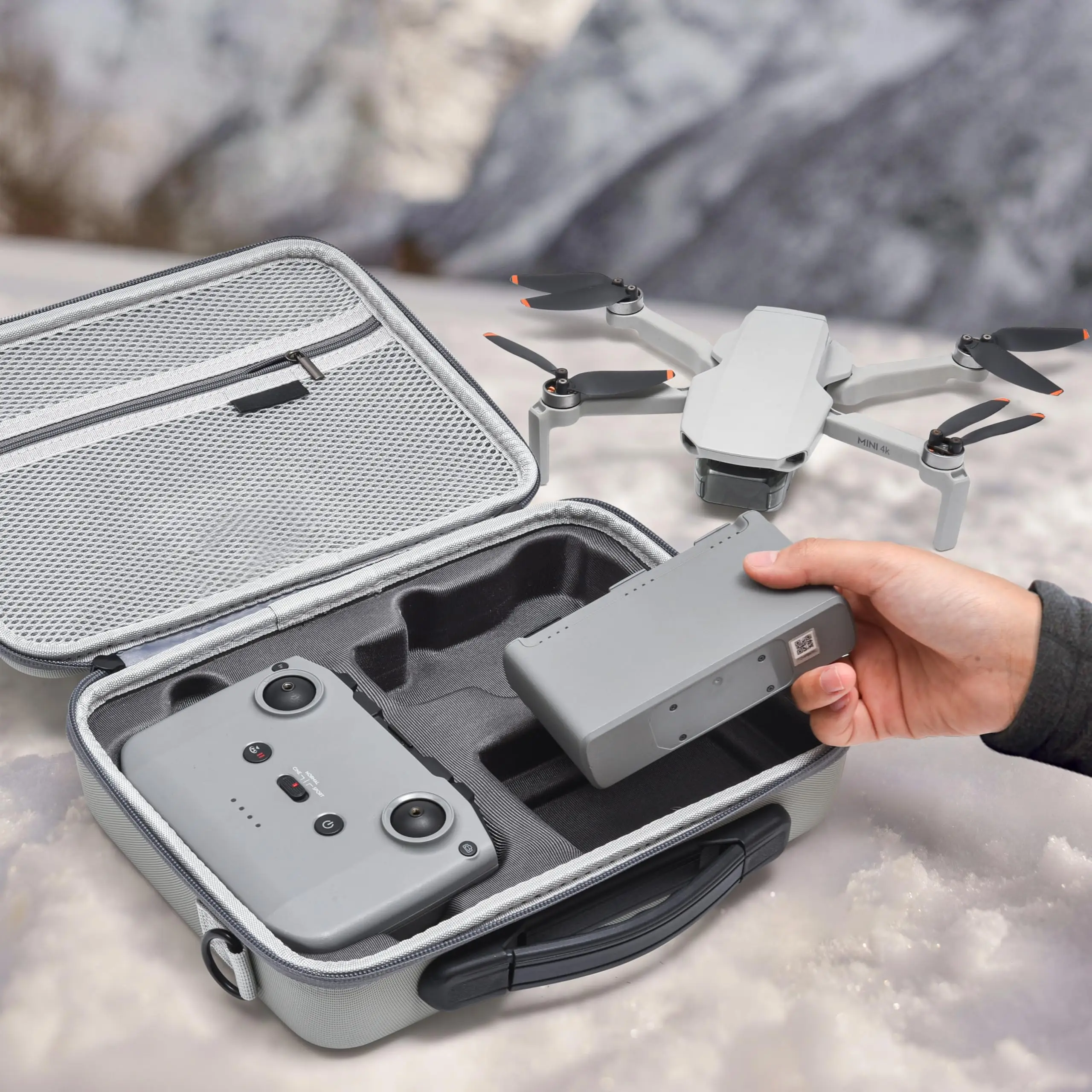 Étui de transport rigide pour DJI Mini 4K, Mini 2 SE et Mini 2 Fly More Combo, posé à côté du drone déplié.