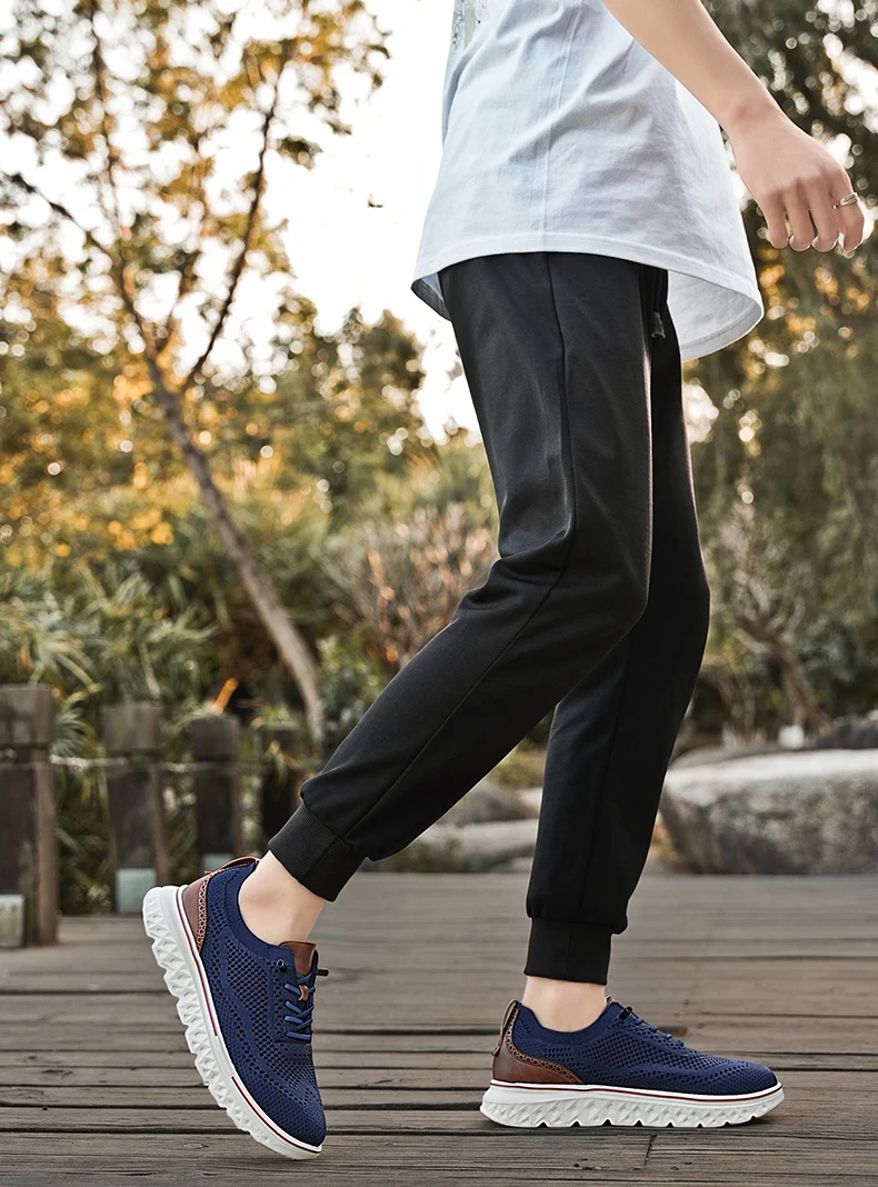 Pair of brown mesh sneakers with soft soles placed on a concrete surface, highlighting breathable texture and sporty silhouette blue