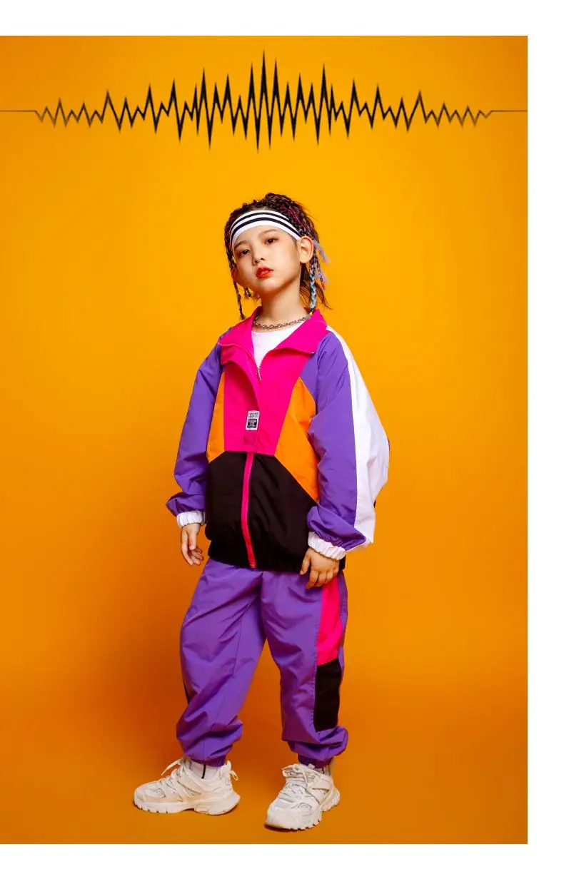 Child wearing patchwork jacket and joggers in hip hop street dance pose 6589